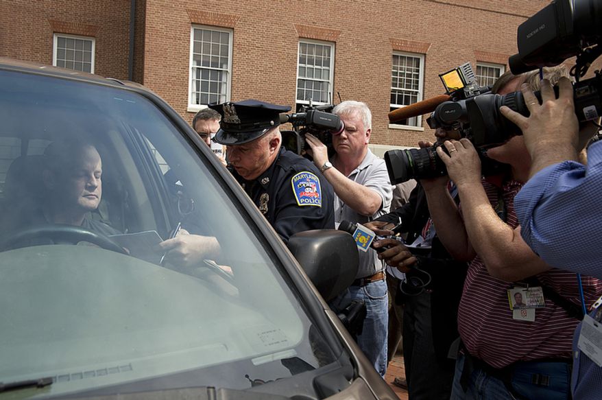 Officer Thomas Crewe with the Maryland Capitol Police gives Carl Garrett of Millersville, Md., a ticket for illegal use of horn for non-emergency purposes after he and a handful of other cars drove around the State House in Annapolis, Md., on Thursday, March 22, 2012, honking their horns in protest of new and increased taxes in the state of Maryland. Garrett says he will fight the ticket, which carries a $60 fine. (Barbara L. Salisbury/The Washington Times)