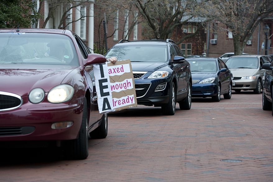 A driver holds a "Taxed Enough Already" sign out of his car as he and a handful of other cars drive around the State House in Annapolis, Md., on Thursday, March 22, 2012, honking their horns in protest of new and increased taxes in the state of Maryland. At least two drivers were ticketed for illegal use of horn, a $60 fine. (Barbara L. Salisbury/The Washington Times)
