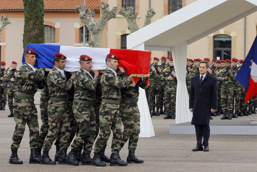 ** FILE ** French President Nicolas Sarkozy stands by soldiers carrying a coffin during a ceremony in Montauban, southwestern France, on March 21, 2012, to pay homage to the three soldiers killed by a suspect claiming al Qaeda links and also suspected in the killings of three Jewish children and a rabbi. (Associated Press)