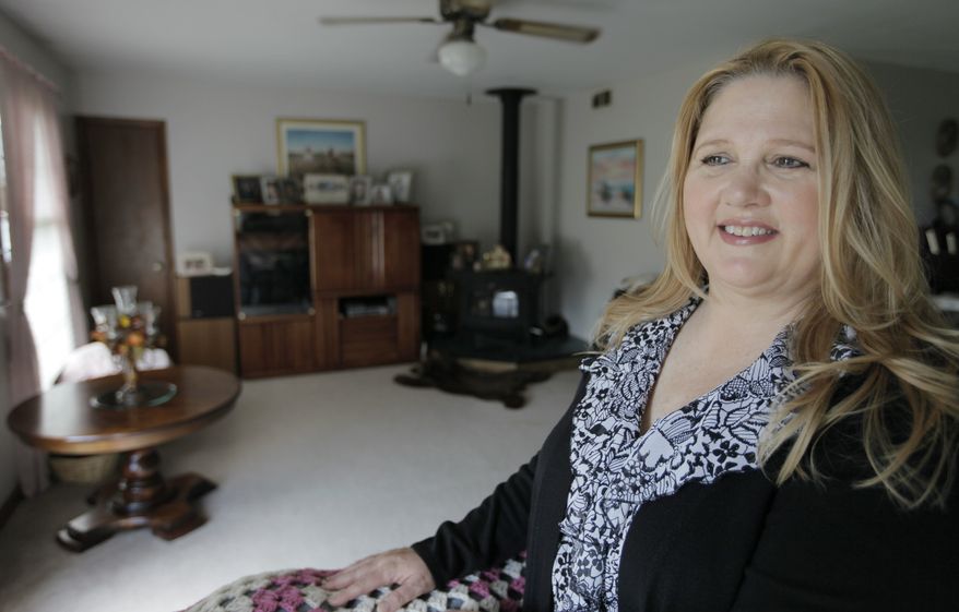 Michelle Chesney-Offutt is seen in her Sandwich, Ill., home before leaving for work as an insurance customer service representative on March 22, 2012. Chesney-Offutt, who was unemployed for nearly three years before landing a job, said a recruiter who responded to her online resume two years ago backed away when he learned she had been out of work for 13 months. (Associated Press)