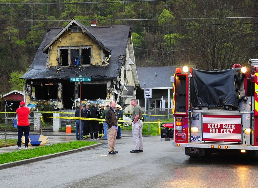 In this photo provided by Jerry Waters, Charleston, W.Va., firefighters and city officials look over the scene of a house fire on Saturday, March 24, 2012, in Charleston. Authorities say a fire broke out at the two-story wood frame home, killing six children and two adults. (AP Photo/Jerry Waters)
