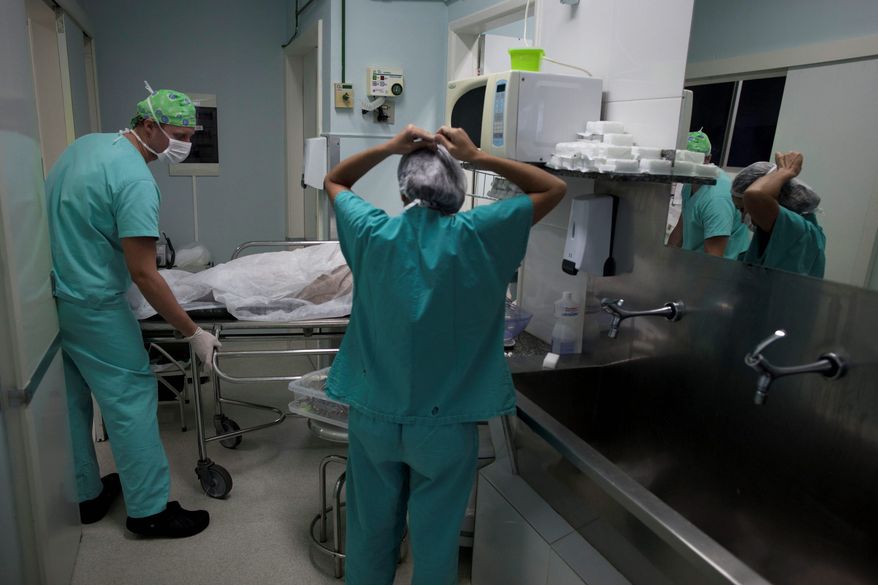 ** FILE ** A doctor wheels a patient out of an operating room at Santa Casa de Misericordia Hospital in Rio de Janeiro. (Associated Press)