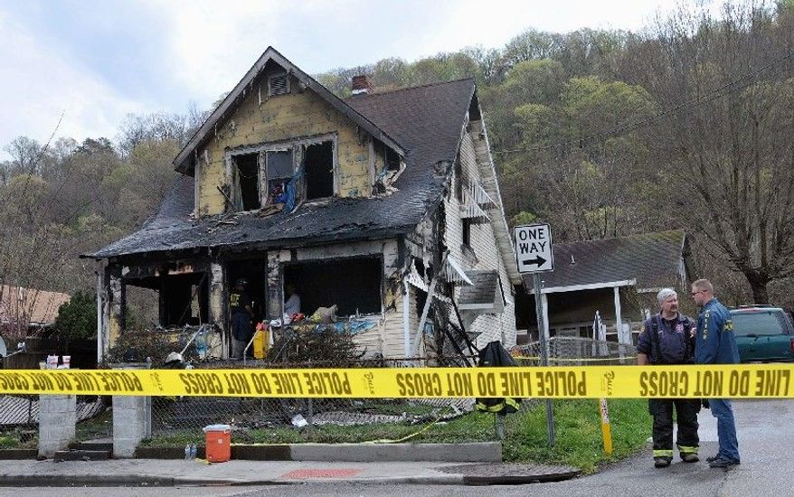 Investigators sift through debris of a house in Charleston, W.Va., where nine people were killed in a fire early Saturday. Charleston Assistant Fire Chief Bob Sharp said the fire appears to have started in the middle of the home's main level. (Associated Press)