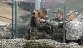 **FILE** President Obama looks through binoculars toward North Korea from Observation Post Ouellette in the Demilitarized Zone, the tense military border between the two Koreas, in Panmunjom, South Korea, on March 25, 2012. With Mr. Obama is Lt. Col. Ed Taylor (right), commander of the U.N. Command Security Battalion-Joint Security Area. (Associated Press)