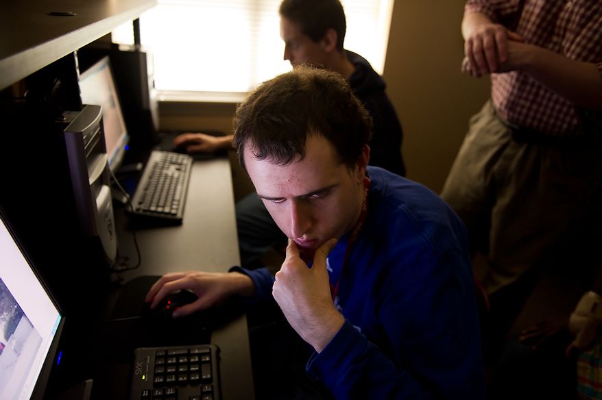 Autistic adults Brian D., bottom, and James L., above, edit their photographs of the Cherry Blossoms taken along the Tidal Basin with the help of staff member Craig Pardini, right, at a computer lab at the Community Services for Autistic Adults and Children, Montgomery Village, Md., Thursday, March 22, 2012. The two are a part of the “InFocus Project†which helps adults with autism to develop forms of self expression and social skills while producing work that has been featured in art shows, given to donors to C.S.A.A.C., and sold on an online store. (Andrew Harnik/The Washington Times)