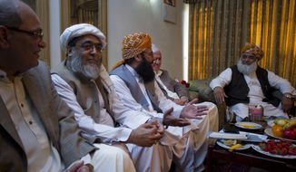 Maulana Fazal-ur-Rehman (right), chief of the Pakistani religious party Jamiat Ulema-e-Islam, heads a meeting of opposition leaders on Saturday, March 24, 2012, in Islamabad to discuss strategy for the forthcoming Parliament debate on the terms of re-engagement with United States. (AP Photo/B.K. Bangash)