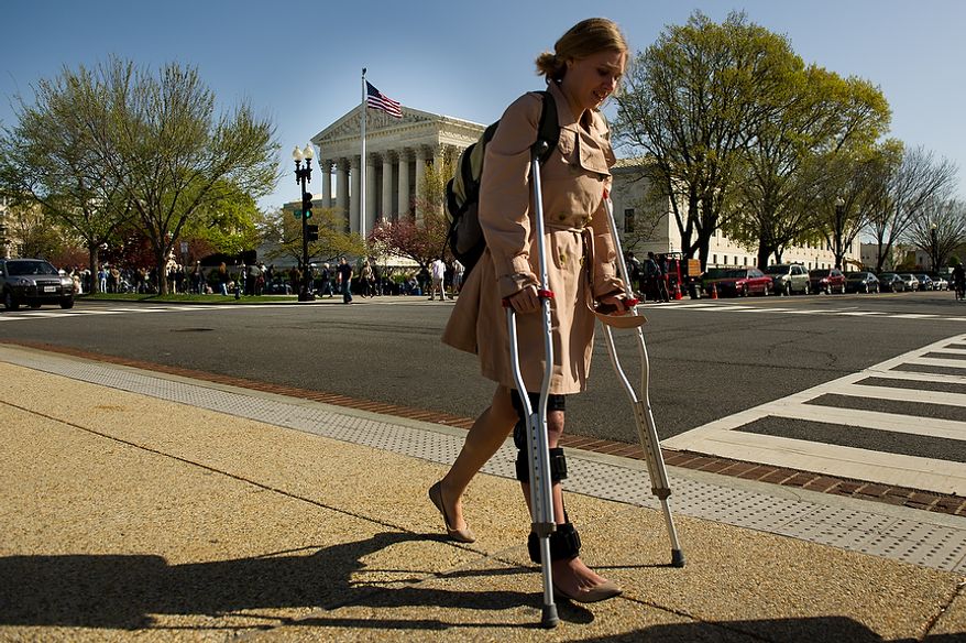 Lydia Mitts, an analyst for health-care advocacy organization Families USA, is seen March 26, 2012, outside the U.S. Supreme Court building in D.C., as the court hears oral arguments on the challenges to the Affordable Care Act. Mitts, who supports the Affordable Care Act, walked with the aid of crutches after recent knee surgery. (Andrew Harnik/The Washington Times)