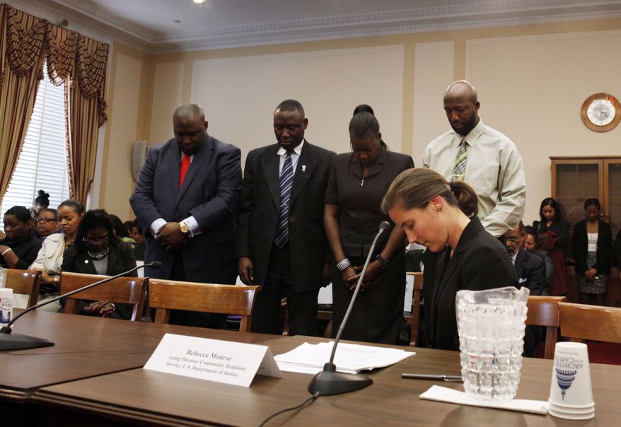 Daryl Parks (from left), president of the National Bar Association; the Martin family lawyer, Benjamin Crump; and Trayvon Martin's parents, Tracy Martin and Sybrina Fulton, stand during a moment of prayer for Trayvon during a House Judiciary Committee Democratic briefing on racial profiling and hate crimes on Capitol Hill in Washington on Tuesday, March 27, 2012. In front is Rebecca Monroe of the Department of Justice. (AP Photo/Jacquelyn Martin)