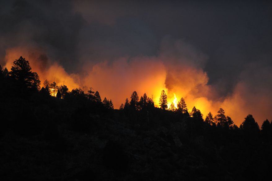 A fast-moving wildfire tops out trees as the blaze just about comes over the ridge on Monday, March 26, 2012, near Reynolds Ranch in Conifer, Colo. (AP Photo/Denver Post, John Leyba)