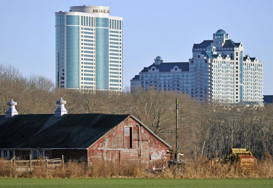 Foxwoods Resorts Casino and the MGM Grand at Foxwoods loom behind a barn in Mashantucket, Conn. Once one of America's wealthiest communities, the Mashantucket Pequot Indian reservation has suffered a financial reversal. (Associated Press)