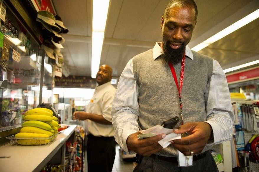 Tyron Carroll of Annapolis (left) and Lewis Wilborn of Hyattsville buy Mega Millions tickets at an Exxon gas station at Bladensburg Road and New York Avenue Northeast on Wednesday. The jackpot has reached $476 million, the biggest in U.S. history, and could go higher before Friday's drawing. (Andrew Harnik/The Washington Times)