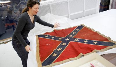 ** FILE ** In this Feb. 24, 2012, photo, Cathy Wright, curator at the Museum of the Confederacy in downtown Richmond, opens an original battle flag from the 3rd Virginia Infantry. The museum is opening a satellite museum Saturday in Appomattox, the first in a regional system of museums. (AP Photo/Richmond Times-Dispatch, Dean Hoffmeyer)