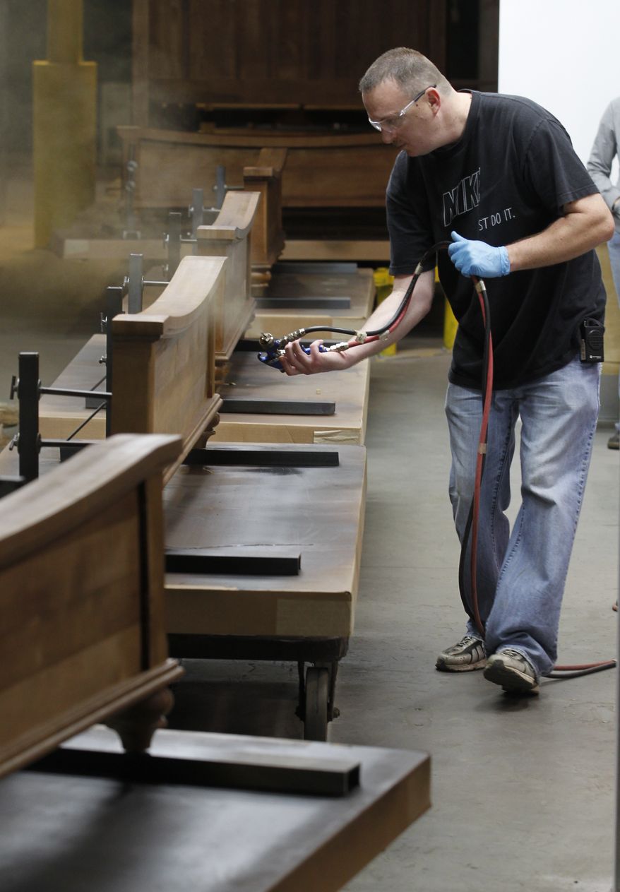 Mark Bollinger sprays a finish on some wooden footboards for beds inside a spray booth at the Lincolnton Furniture Company in Lincolnton, N.C., on March 16, 2012. (Associated Press)