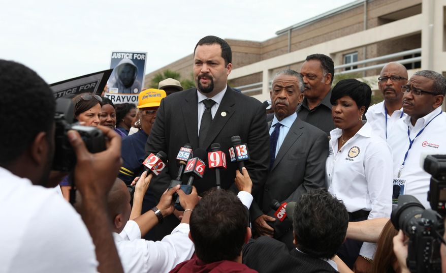 Benjamin Jealous, president of the NAACP, talks to the media as the Rev. Al Sharpton and the Rev. Jessie Jackson, back, listens before the march and rally for slain Florida teenager Trayvon Martin on Saturday, March 31, 2012, in Sanford, Fla. (AP Photo/Julie Fletcher)