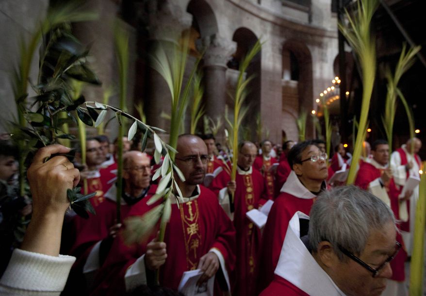 Catholic priests hold palm fronds at the Church of the Holy Sepulchre, traditionally believed to be the site of the crucifixion and burial of Jesus Christ, in Jerusalem's Old City on Sunday, April 1, 2012. For Christians, Palm Sunday marks the beginning of Holy Week. (AP Photo/Sebastian Scheiner)
