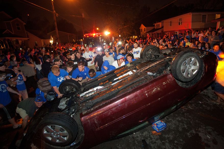 University of Kentucky fans flip a car on State Street in Lexington, Ky., as they celebrate Kentucky's 69-61 win over cross-state rival Louisville in an NCAA Final Four semifinal college basketball tournament game on Saturday, March 31, 2012. (AP Photo/Lexington Herald-Leader, Jonathan Palmer)