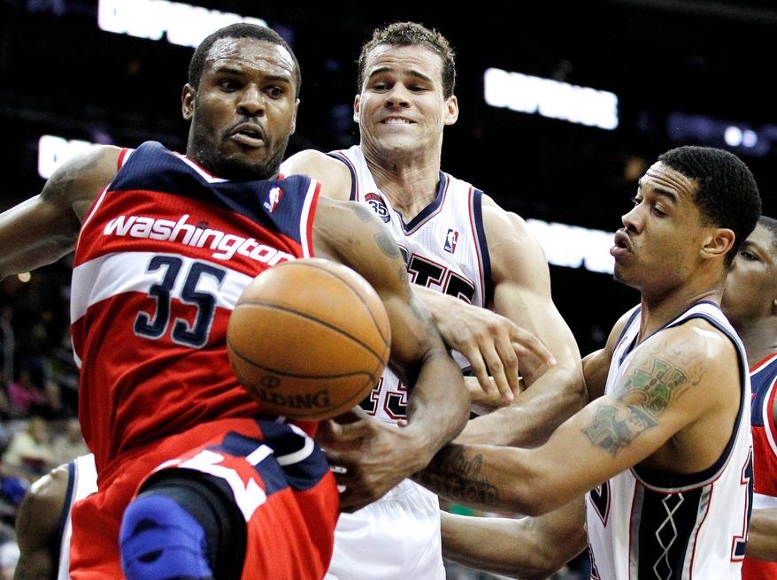 Washington's Trevor Booker (left), shown against New Jersey on March 21, is in a walking boot, the result of an injury suffered in Friday night's win over Philadelphia. (Associated Press)
