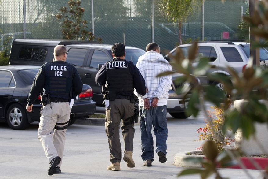 Immigration and Customs Enforcement (ICE) agents take a suspect into custody in Chula Vista, Calif., on Friday, March 30, 2012, as part of a nationwide immigration sweep. (AP Photo/Gregory Bull)