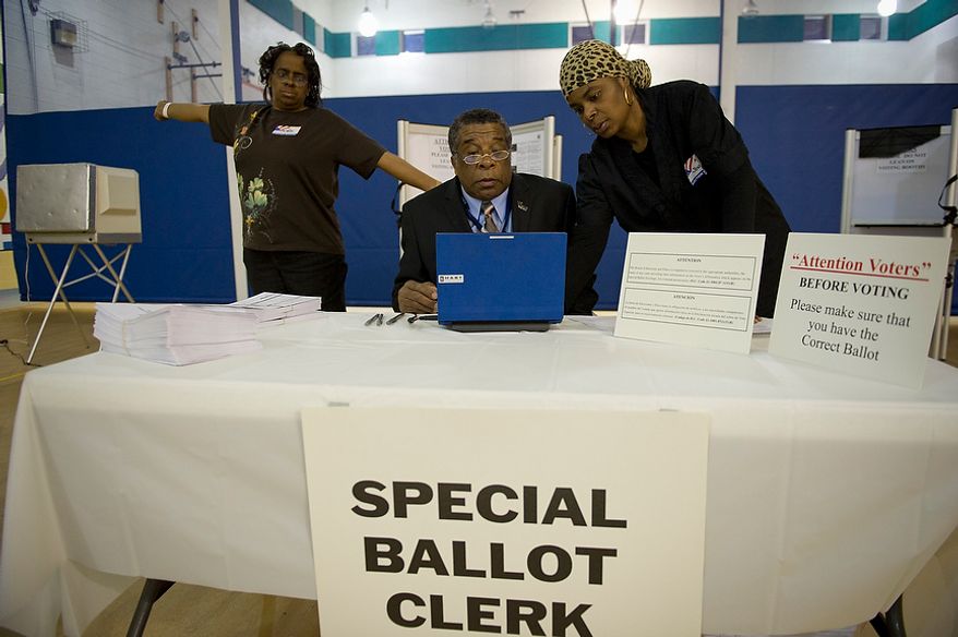 In the pre-dawn hours, election officials (from left) Denise McNeal, Charles Hudson and Quanic Jenkins prepare voting equipment at the Randle Highlands Elementary School in Washington as the nation's capital holds its primary election on Tuesday, April 3, 2012. (Rod Lamkey Jr./The Washington Times)