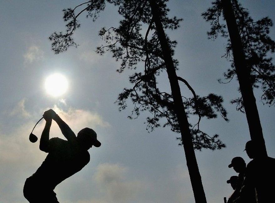Tiger Woods, shown on the 14th hole during a practice round at Augusta, will be going for his fifth green jacket when the Masters begins Thursday. His first victory came in 1997, when he shot 18 under par. (Associated Press)