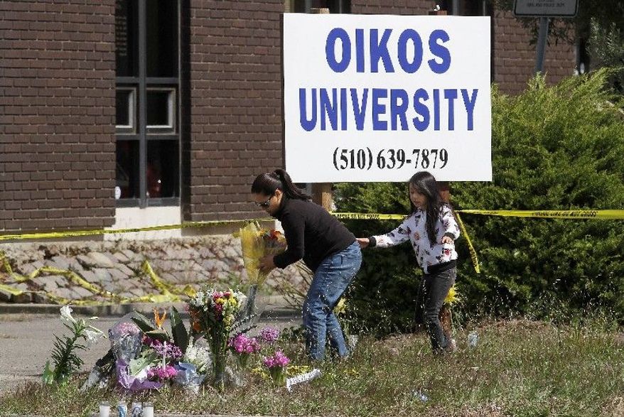 Maria Campomanes and her daughter Maelauni, 9, on Wednesday leave flowers for victims of the Oikos University shooting. Ellen Cervellon, an official at the college, said she was the intended target. (Associated Press)