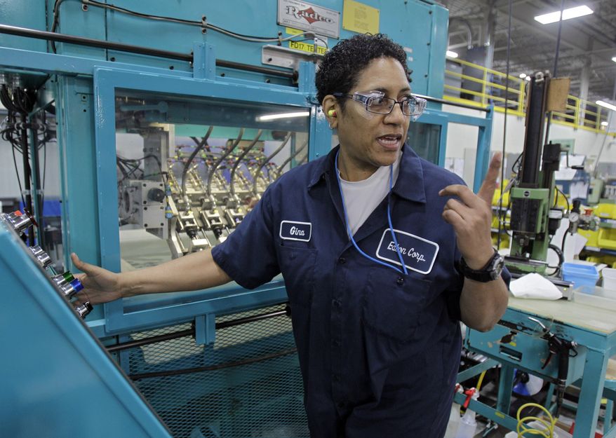 **FILE** Gina Johnson performs leak tests on hydraulic fittings at the Eaton Corp. plant in Berea, Ohio, on Jan. 25, 2012. (Associated Press)