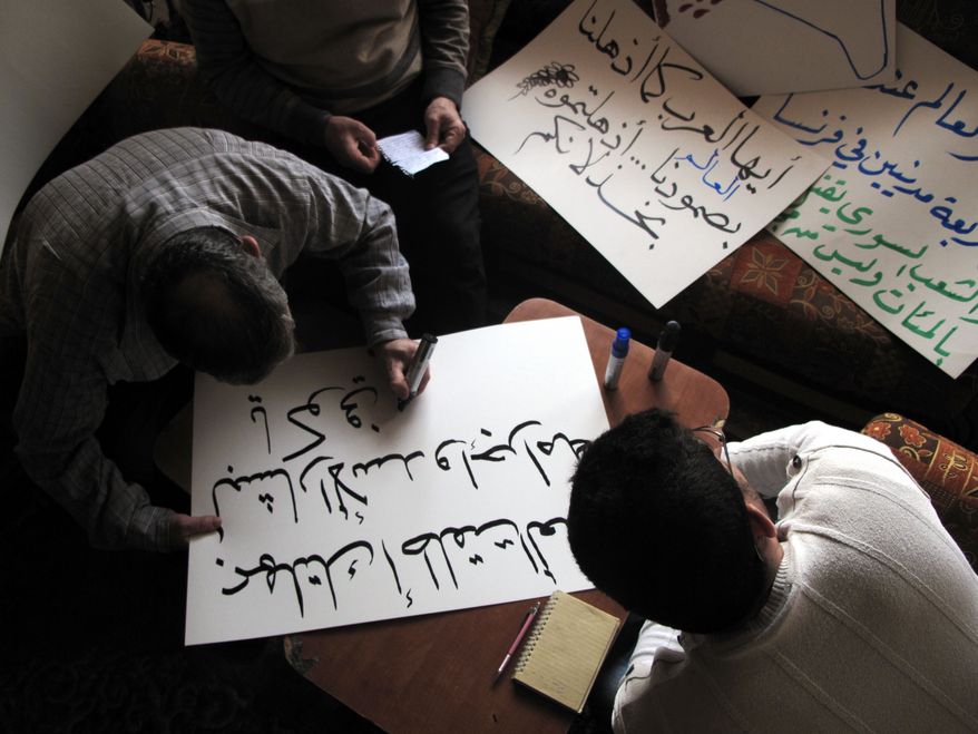 Syrian activists prepare signs for upcoming protests at a house in Damascus, Syria, on April 3, 2012. Syrian activists say there have been explosions and clashes in several parts of the country even as the government claims it has started to withdraw troops from some cities in compliance with an international cease-fire plan. (Associated Press)