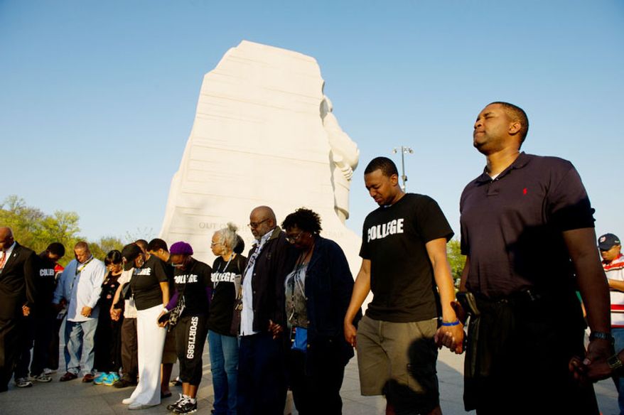 ** FILE ** Vince Richardson of Las Vegas, Nev., right, and others participates in a prayer circle led by the Men's Choir of the People's Community Baptist Church in Silver Spring, Md., before dignitaries lead a candle light vigil at the Martin Luther King, Jr. Memorial on the 44th Anniversary of King's assassination, Washington, D.C., Wednesday, April 4, 2012. (Andrew Harnik/The Washington Times)