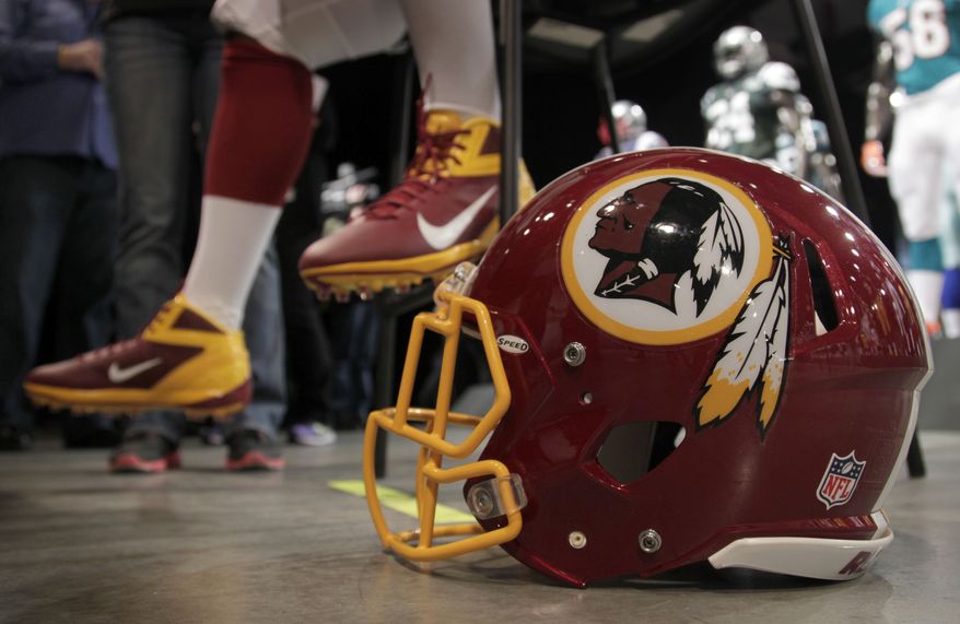 A Washington Redskins player is interviewed April 3, 2012, while his helmet sits on the floor during a presentation in New York. (Associated Press)