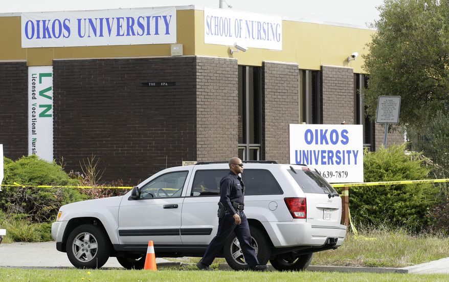 An Oakland police officer walks outside of Oikos University in Oakland, Calif., on Tuesday, April 3, 2012. (AP Photo/Jeff Chiu)