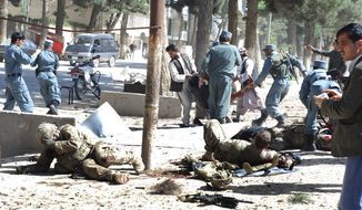 Wounded U.S. soldiers lie on the ground at the scene of a suicide attack in Maimanah, the capital of Faryab province, north of Kabul, Afghanistan, on Wednesday, April 4, 2012. (AP Photo/Gul Buddin Elham)