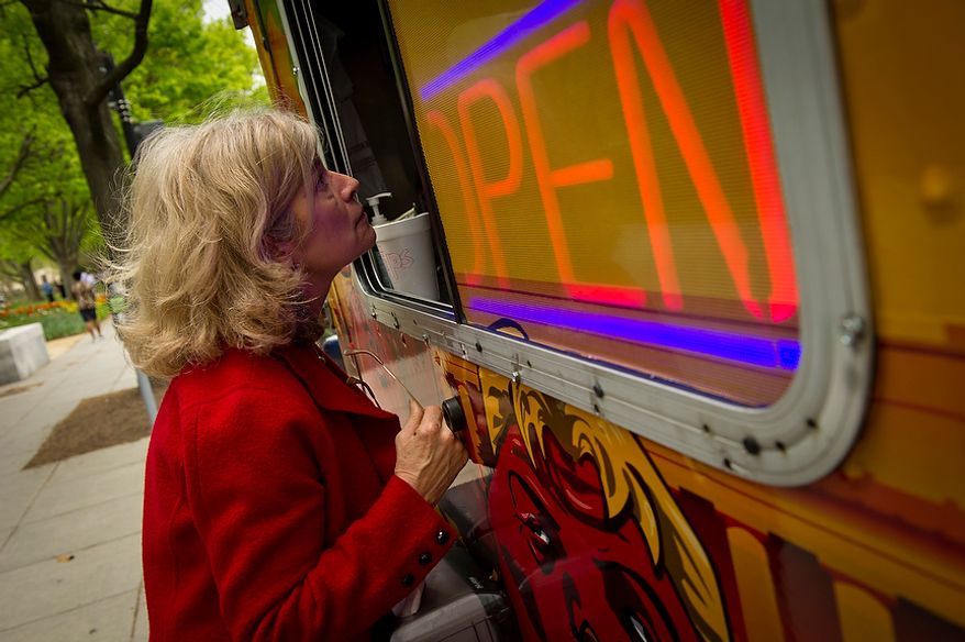Shari Villarosa of Washington, D.C. talks with Feelin' Crabby? food truck owner Alex Tsamouras as she orders lunch at the Feelin' Crabby? food truck, parked near the corner of Virginia Avenue 20th Street NW and in Washington, D.C., Wednesday, April 4, 2012. (Rod Lamkey Jr/The Washington Times)