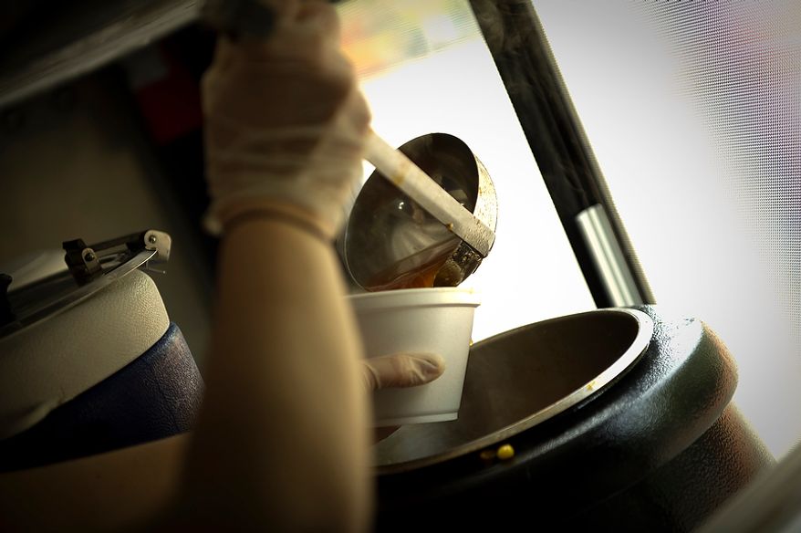 Sophia Stellabotte spoons up a serving of crab soup at the Feelin' Crabby? food truck, parked near the corner of Virginia Avenue 20th Street NW and in Washington, D.C., Wednesday, April 4, 2012. (Rod Lamkey Jr/The Washington Times)