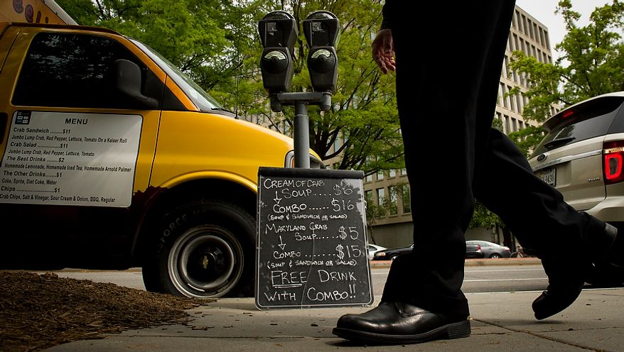 A man passes by the menu as it rests against a parking meter, at the Feelin' Crabby? food truck, parked near the corner of Virginia Avenue 20th Street NW and in Washington, D.C., Wednesday, April 4, 2012. (Rod Lamkey Jr/The Washington Times)