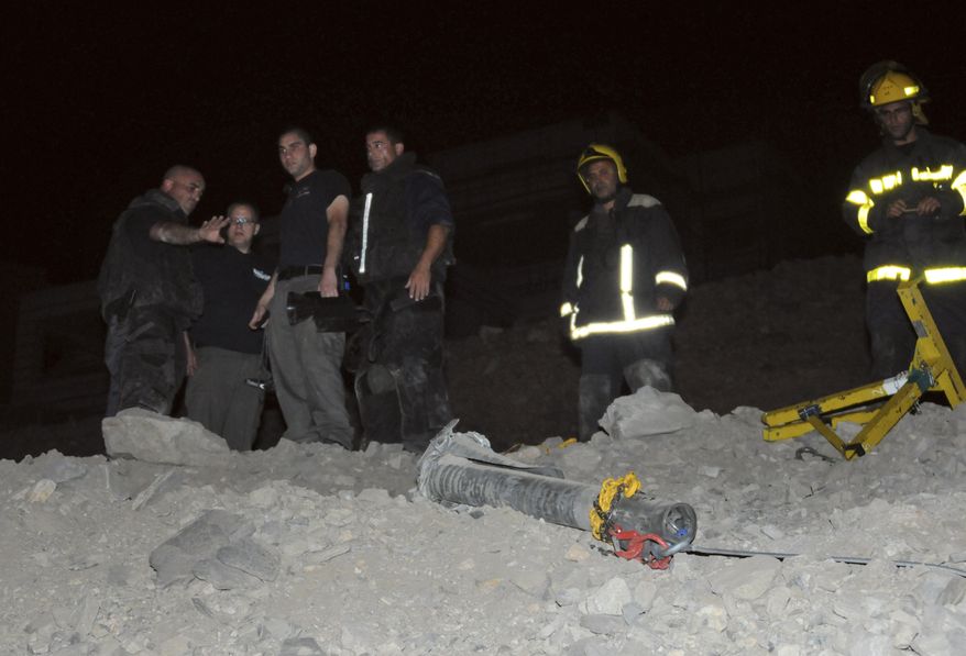 Israeli police stand next to a rocket that landed in the resort town of Eilat in southern Israel, early April 5, 2012. At least one rocket hit Eilat near the Egyptian and Jordanian borders, Israeli police said, causing no injuries. A police spokesperson said the rocket was likely launched from Egypt's Sinai Peninsula. (Associated Press)