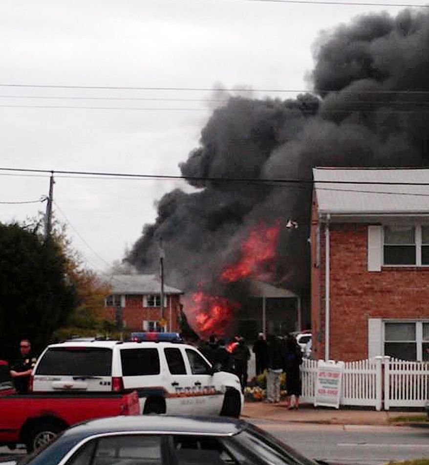 In this image made from video and provided by WVEC-TV, smoke billows near an apartment complex where a Navy jet crashed in Virginia Beach, Va., on April 6, 2012. The F/A-18 Hornet crashed into the apartment building, officials said, and the two-member crew ejected safely. There were no immediate reports of injuries on the ground. (Associated Press/WVEC-TV)