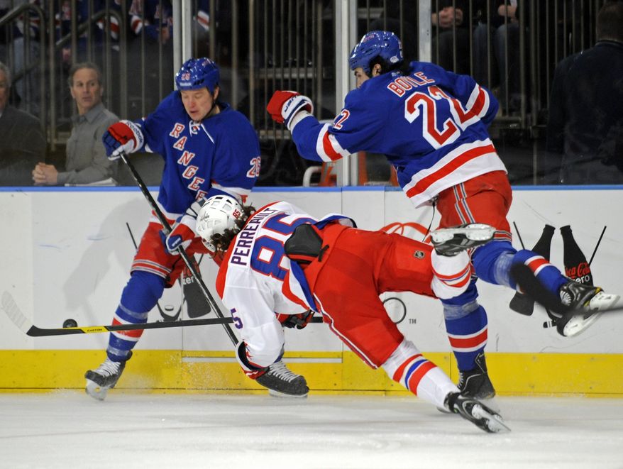 Washington Capitals&#39; Mathieu Perreault (85) is sent flying on a check by New York Rangers&#39; Brian Boyle, right, as Rangers Ruslan Fedotenko, of Ukraine, looks on during the first period of an NHL hockey game Saturday, April 7, 2012, at Madison Square Garden in New York. (AP Photo/Bill Kostroun)