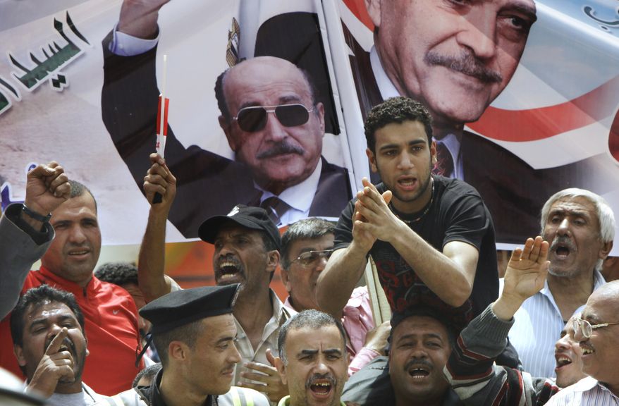 Supporters of Gen. Omar Suleiman chant in front of his posters outside the Higher Presidential Elections Commission in Cairo on Sunday, April 8, 2012. (AP Photo/Amr Nabil)