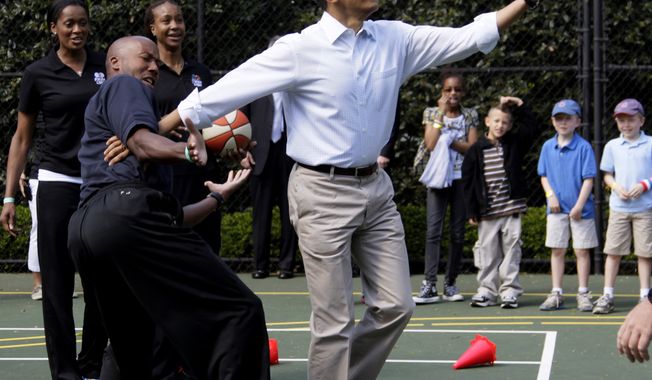 **FILE** President Obama plays basketball with former NBA player Bruce Bowen on April 9, 2012, during the annual White House Easter Egg Roll. (Associated Press)