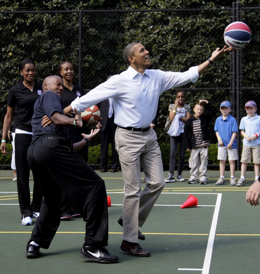 **FILE** President Obama plays basketball with former NBA player Bruce Bowen on April 9, 2012, during the annual White House Easter Egg Roll. (Associated Press)