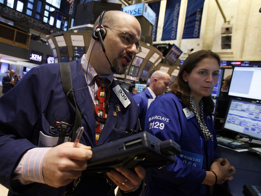 Trader Luigi Muccitelli (left) and specialist Jennifer Klesaris work on the floor of the New York Stock Exchange on Monday, April 9, 2012, in New York. (AP Photo/Richard Drew)
