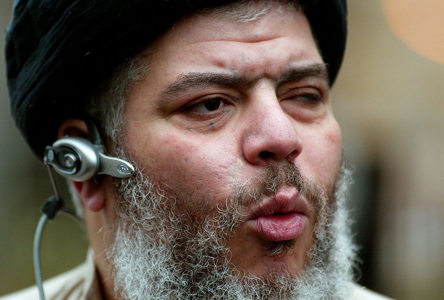 ** FILE ** Self-styled cleric Abu Hamza al-Masri leads his followers in prayer outside Finsbury Park Mosque in London in January 2004 on the first anniversary of its closure by anti-terrorism police. (AP Photo/John D. McHugh)
