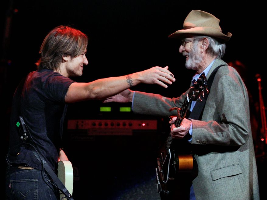 Keith Urban (left) greets Don Williams on the stage to perform during a concert Tuesday in Nashville, Tenn. "I heard more records in my house growing up by this guy than anybody," Mr. Urban said. (Associated Press)