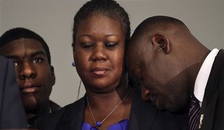 ** FILE ** Sybrina Fulton (center), the mother of Trayvon Martin, closes her eyes as the family attorney Benjamin Crump rests his head against her shoulder April 11, 2012, during a news conference at the Washington Convention Center in Washington about the arrest of George Zimmerman for the killing of Martin. To her right is her son, Jahvaris Fulton. (Associated Press)