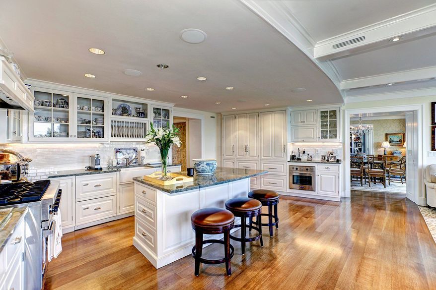 The kitchen in units 404 and 405 in Watergate South features granite counters, a center island with a breakfast bar, custom-designed cabinets and a coffered ceiling.