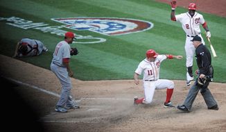 Ryan Zimmerman crosses home plate on a wild pitch, giving the Nationals a 3-2, 10-inning win in their home opener. Arriving to congratulate Zimmerman is Roger Bernadina. (Rod Lamkey Jr./The Washington Times)
