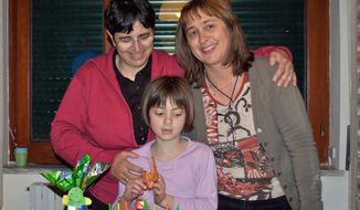 In this 2011 family photo, lesbian couple Giuseppina La Delfa (left) and Raphaelle Hoedts (right) celebrate the eighth birthday of their daughter, Lisa-Marie, in Naples, Italy. (Associated Press)