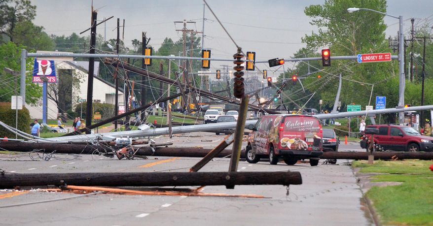 Downed power lines litter 24th Avenue Southwest at the Lindsey Street intersection after a tornado hit Friday afternoon April 13, 2012, in Norman, Okla. (AP Photo/The Norman Transcript, Kyle Phillips)