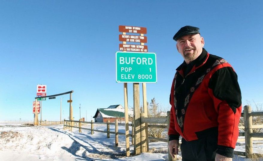 Buford resident Don Sammons stands in front of the population sign in Buford, Wyo. Vietnamese businessman Pham Dinh Nguyen flew to the U.S. for the first time and bought his own piece of the American dream: Buford. Mr. Nguyen, who bid $900,000 for Buford, runs a company in southern Ho Chi Minh City. (Associated Press)