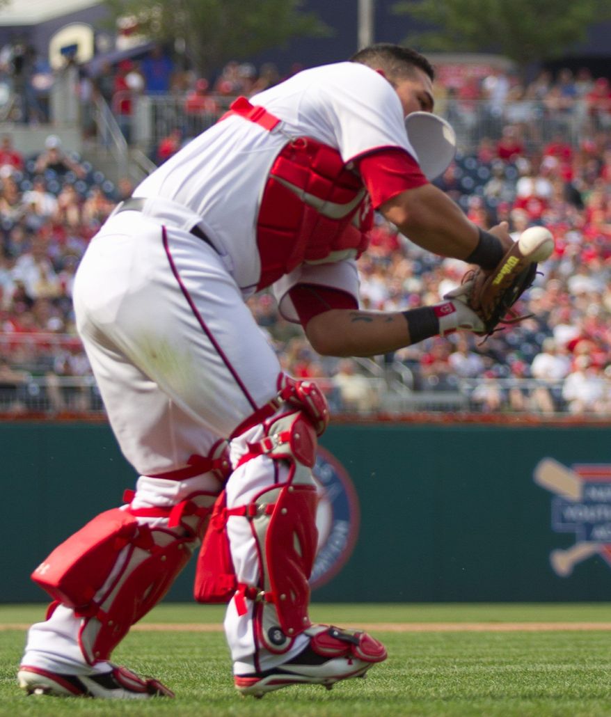 Nationals catcher Wilson Ramos can't put the squeeze on Reds pitcher Mike Leake's sacrifice bunt attempt in the seventh. Leake was thrown out by third baseman Ryan Zimmerman. (Associated Press)